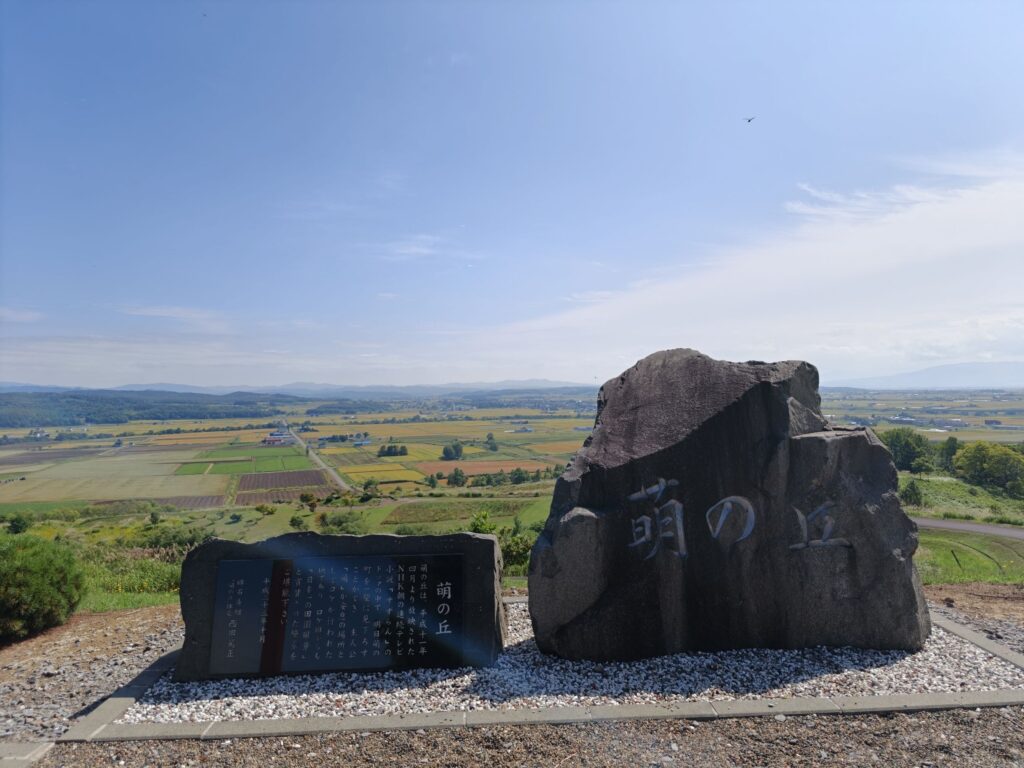 萌の丘の石碑とそこから見下ろす沼田町ののどかな田園風景